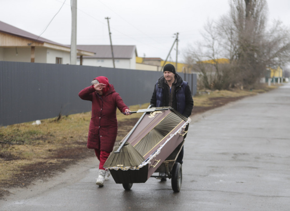Meštani nose kovčeg posle granatiranja u malom gradu nedaleko od Kijeva