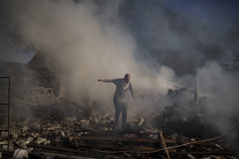 Muškarac hoda po ostacima zapaljene kuće, uništene nakon ruskog napada na Harkov