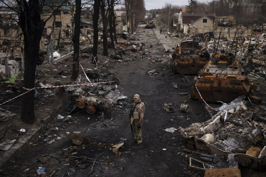 Ukrajinski vojnik stoji među uništenim ruskim tenkovima u Buči
